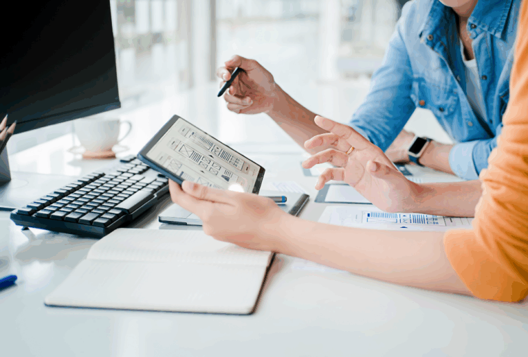 Two people go over a local SEO checklist for businesses in front of a computer