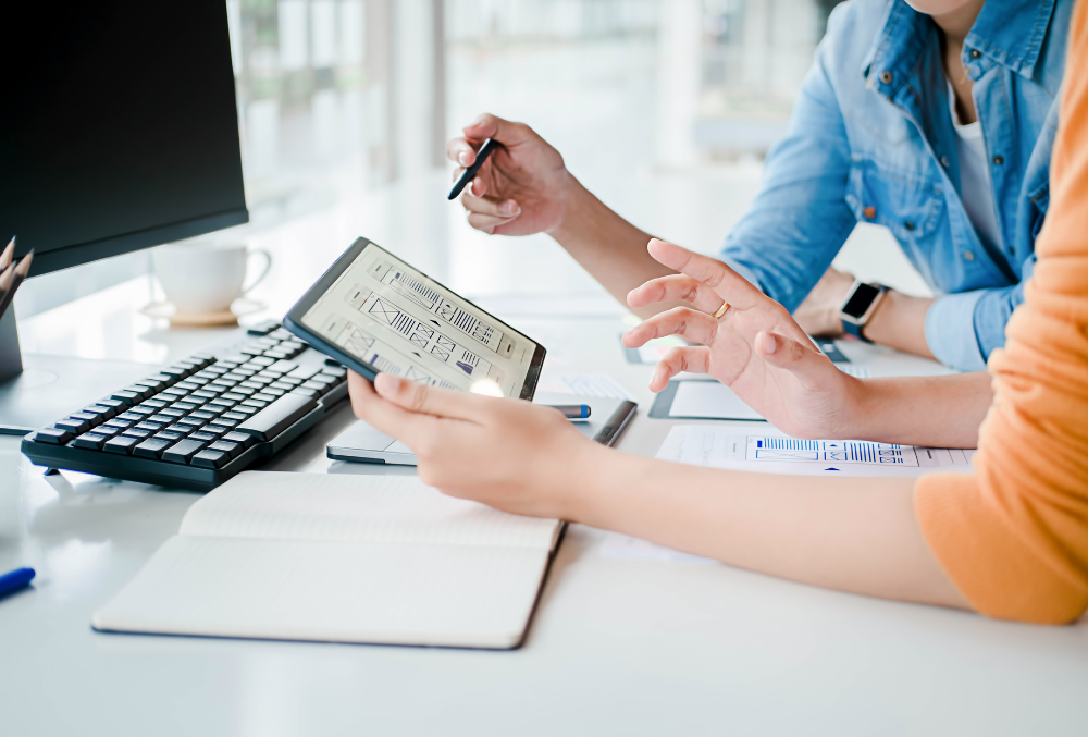 Two people go over a local SEO checklist for businesses in front of a computer